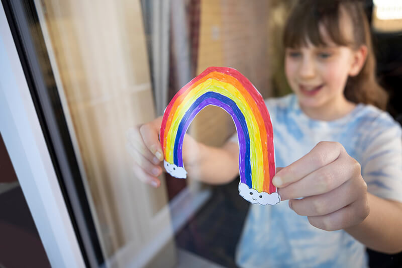 girl holding rainbow drawing